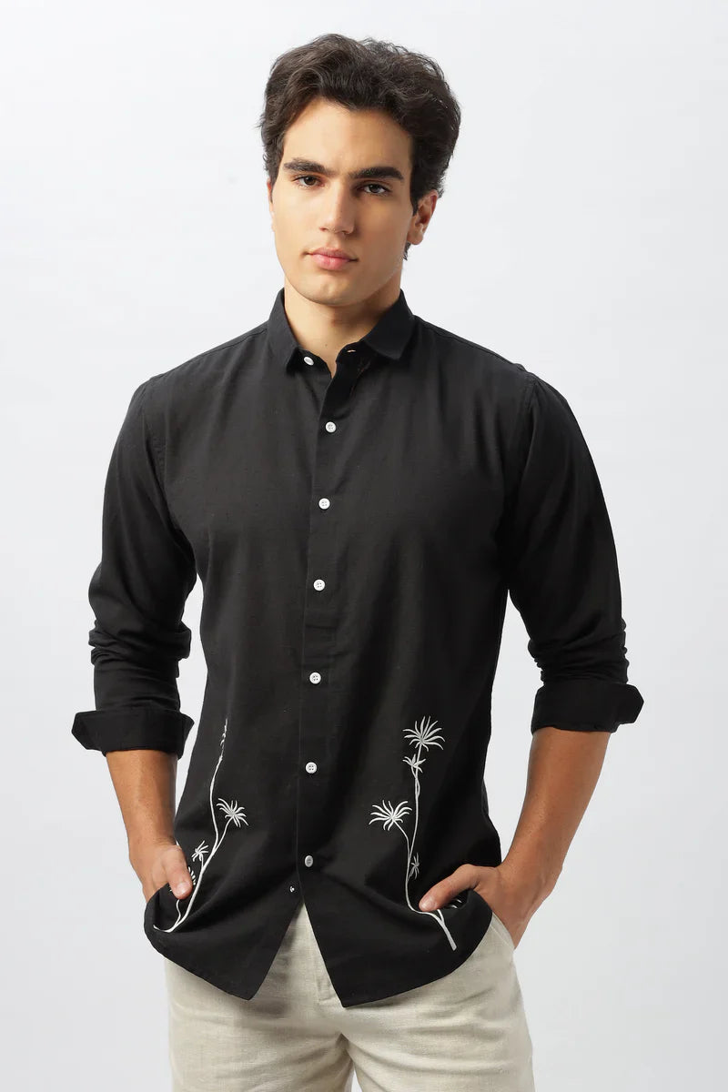 Man in a black shirt with white embroidered palms